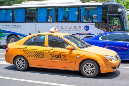 Hainan Island, Sanya, China - May 18, 2019: Taxi. Chinese yellow taxi on the street of Sanyaのeditorial素材