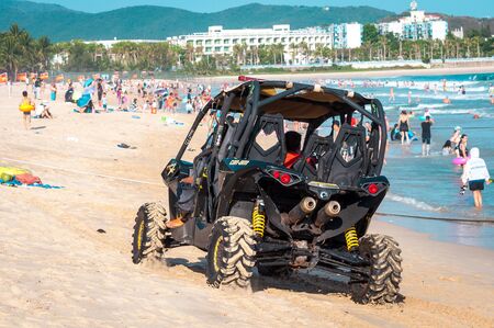 China, Hainan Island, Sanya, Dadonghai Bay - May 16, 2019: Unidentified vehicle drives along the beach of Dadonghai Bayのeditorial素材