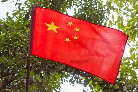 The flag of China against the green leafsの写真素材