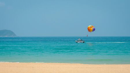 Parasailing, parascending, parakiting - is a this fascinating active form of recreation. where a person is towed by a boat and he flies with a parachute over the waterの写真素材