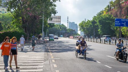 Sanya, Hainan island, China - May 15, 2019: Road traffic. A lot of electric cars. Hybrid buses. 90 percent of mopeds are electric. From 2030, only electric transport will be allowed on the island.のeditorial素材