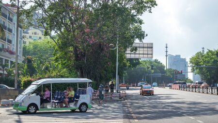 Sanya, Hainan island, China - May 15, 2019: Road traffic. A lot of electric cars. Hybrid buses. 90 percent of mopeds are electric. From 2030, only electric transport will be allowed on the island.のeditorial素材