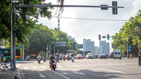 Sanya, Hainan island, China - May 15, 2019: Road traffic. A lot of electric cars. Hybrid buses. 90 percent of mopeds are electric. From 2030, only electric transport will be allowed on the island.のeditorial素材
