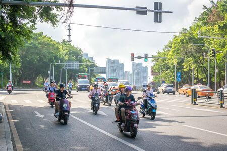 Sanya, Hainan island, China - May 15, 2019: Road traffic. A lot of electric cars. Hybrid buses. 90 percent of mopeds are electric. From 2030, only electric transport will be allowed on the island.のeditorial素材