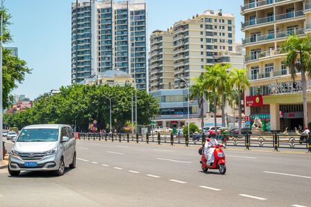 Sanya, Hainan island, China - May 15, 2019: Road traffic. A lot of electric cars. Hybrid buses. 90 percent of mopeds are electric. From 2030, only electric transport will be allowed on the island.のeditorial素材