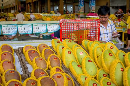 Sanya, Hainan, China - May 18, 2019: Typical Asian fruit market. Fresh tropical fruits are on the market window. Healthy, organic foodのeditorial素材