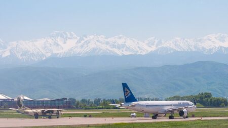 Almaty, Kazakhstan - May 10, 2019: View from the airfield of Almaty on the Zaili Alatau. Parked Airbus A320neo of the largest Kazakhstani air carrier AIR ASTANA.のeditorial素材