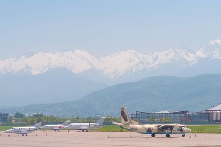 Almaty, Kazakhstan - May 10, 2019: View from the airfield of Almaty on the Zaili Alatau, a mountain range in the north-west of the Tien Shan. Various airplanes are parked on the airfield.のeditorial素材