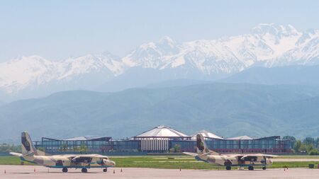 Almaty, Kazakhstan - May 10, 2019: View from the airfield of Almaty on the Zaili Alatau, a mountain range in the north-west of the Tien Shan. Various airplanes are parked on the airfield.のeditorial素材