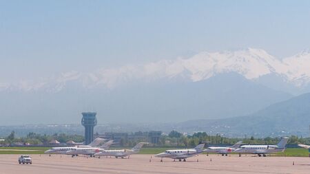 Almaty, Kazakhstan - May 10, 2019: View from the airfield of Almaty on the Zaili Alatau, a mountain range in the north-west of the Tien Shan. Various airplanes are parked on the airfield.のeditorial素材
