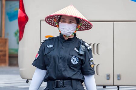 Haikou, Hainan, China - May 11, 2019: Service staff in the park of an extinct volcano Rock Hill Volcanoe Haikou. Chinese woman in uniform, working clothes rangers.のeditorial素材