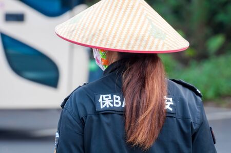 Haikou, Hainan, China - May 11, 2019: Service staff in the park of an extinct volcano Rock Hill Volcanoe Haikou. Chinese woman in uniform, working clothes rangers.のeditorial素材