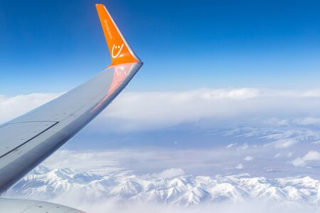 Kazakhstan - May 10, 2019: View from Zaili Alatau, a mountain range in the north-west of Tien Shan. The plane of the Ukrainian airline SkyUp. The inscription on the wing of the aircraft skyup.aero.のeditorial素材