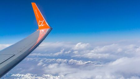 Kazakhstan - May 10, 2019: View from Zaili Alatau, a mountain range in the north-west of Tien Shan. The plane of the Ukrainian airline SkyUp. The inscription on the wing of the aircraft skyup.aero.のeditorial素材