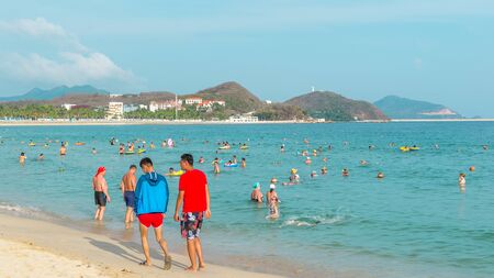 Hainan, China - May 14, 2019: On a bright sunny day on a tropical beach, people swim in the sea, relax on the sandのeditorial素材