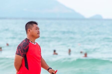 Sanya, China - May 15, 2019: A lifeguard on beach keeps order and safety. In the hands of a whistle to ensure the disciplineのeditorial素材
