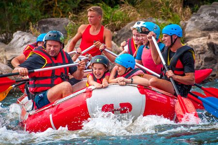 Myhia, Ukraine - August 17, 2019: Rafting. A cheerful group of men and women descends on a large inflatable boat on the river. There is a child in the boat. Sincere emotions of happy people.のeditorial素材