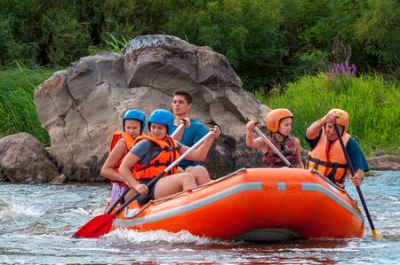 Myhia, Ukraine - August 17, 2019: Rafting. A cheerful group of men and women descends on a large inflatable boat on the river. Sincere emotions of happy people.のeditorial素材