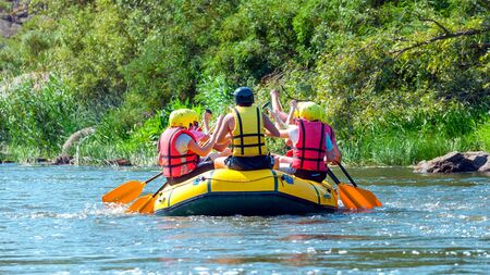 Rafting trip. A group of men and women descends on a large inflatable boat on the river.の写真素材