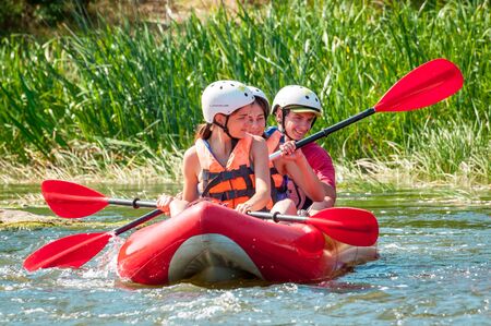 Myhiya, Ukraine - August 17, 2019: Rafting. Three young people descend in an inflatable boat on the river. Sincere emotions of people. Healthy lifestyle concept.のeditorial素材