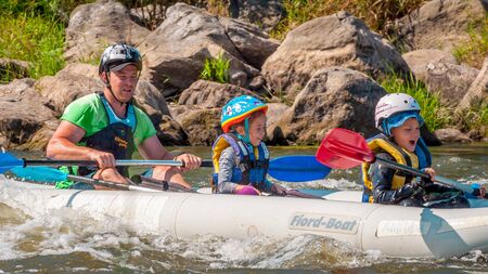 Myhiya, Ukraine - August 17, 2019: Rafting. Father with two children descend on an inflatable boat on the river. Sincere emotions of people. Happy family concept.のeditorial素材