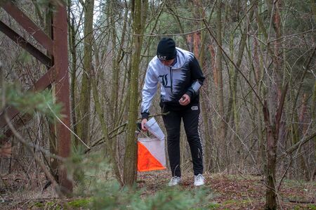 Katerynka, Ukraine - December 13, 2019: Orienteering. Traditional annual game. Young athlete marks the passage of the control pointのeditorial素材