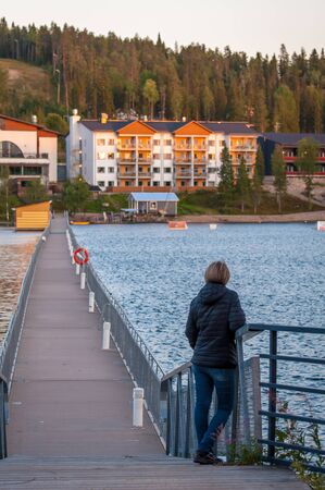 Finland - August 19, 2018. Ukkohalla Ski Resort. The most environmentally friendly air. A lake in the middle of a forest. Cozy picturesque cottages. Footbridge across the lakeのeditorial素材