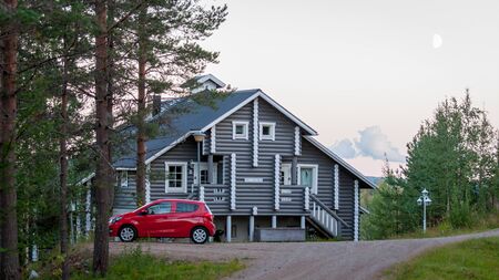 Finland - August 19, 2018. Ukkohalla Ski Resort is located in Central Finland. A cozy picturesque cottage in the middle of an ecologically clean coniferous forest. A red car is parked near the houseのeditorial素材