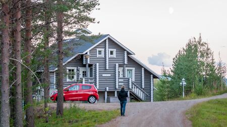 Finland - August 19, 2018. Ukkohalla Ski Resort is located in Central Finland. A cozy picturesque cottage in the middle of an ecologically clean coniferous forest. A red car is parked near the houseのeditorial素材