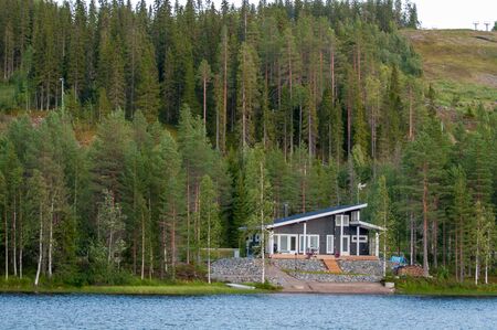 Finland - August 19, 2018. Ukkohalla Ski Resort is located in Central Finland, the Kainuu region. The most environmentally friendly air. A lake in the middle of a forest. Cozy picturesque cottagesのeditorial素材