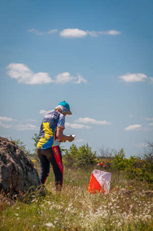Village Aktovo, Ukraine - May 21, 2021: Orienteering race. Traditional annual game. Athlete during orienteering, checkpointのeditorial素材