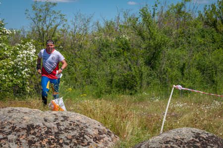 Village Aktovo, Ukraine - May 21, 2021: Orienteering race. Traditional annual game. Athlete during orienteering, checkpointのeditorial素材