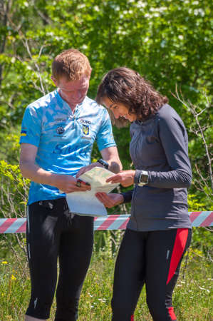 Village Aktovo, Ukraine - May 21, 2021: Orienteering race. Traditional annual game. Analysis of the distance traveled by the athlete and his coachのeditorial素材