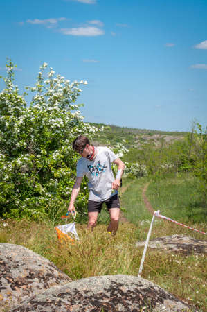 Village Aktovo, Ukraine - May 21, 2021: Orienteering race. Traditional annual game. Athlete during orienteering, checkpointのeditorial素材