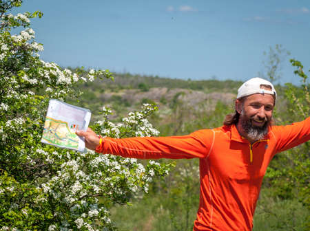 Village Aktovo, Ukraine - May 21, 2021: Orienteering race. Traditional annual game. Cheerful athlete during orienteeringのeditorial素材