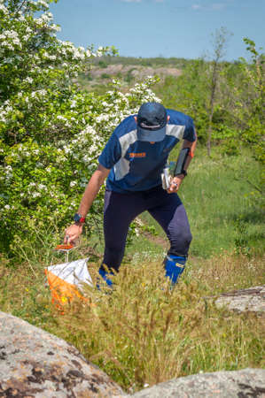 Village Aktovo, Ukraine - May 21, 2021: Orienteering race. Traditional annual game. Athlete during orienteering, checkpointのeditorial素材