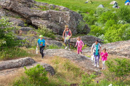 Village Aktovo, Ukraine - May 21, 2021: Orienteering race. Traditional annual game Partisan Spark Cup 2021. An adult athlete and a group of children-athletes on the route of orienteering.のeditorial素材