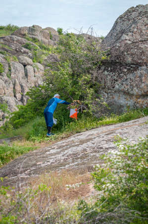 Village Aktovo, Ukraine - May 21, 2021: Orienteering race. Traditional annual game. Athlete during orienteering, checkpointのeditorial素材