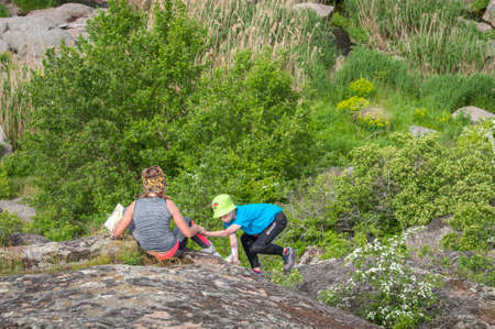 Village Aktovo, Ukraine - May 21, 2021: Orienteering race. Traditional annual game. Athlete during orienteering trail. Young athletes helping each other overcome the difficult part of the routeのeditorial素材