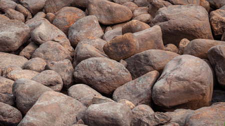 Many orange and red pebble stones are on the ground. Rock natural pattern, background, abstract, texture. Close-upの写真素材