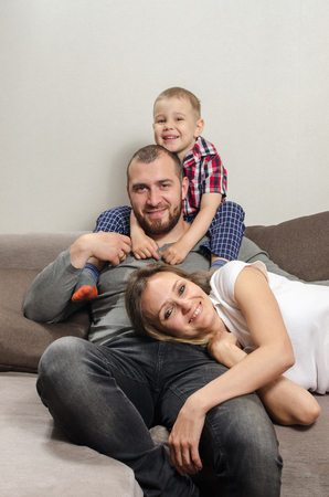 happy family, dad, mom and child on the couchの写真素材