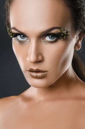 beauty portrait of attractive woman with large patch of green eyelashes featherの写真素材