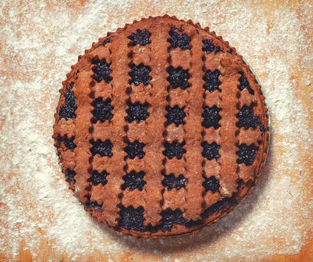 Dark cookie. Stuffed Cocoa Pie. Sprinkle flour on the board. Fresh pie from the oven.の写真素材