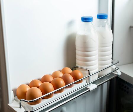 Milk and eggs in the door fridge. Organic Chicken Eggs Keep Fresh In The Fridge. Brown eggs in the tray. Organic Chicken Eggs Keep Fresh In The Fridge.の写真素材