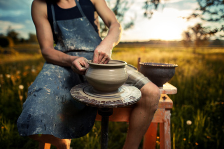 Hands of young potter, was produced on range of pot in open air