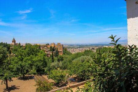 Garden inside the Alhambra fortress against the backdrop of mountains and the cityの写真素材