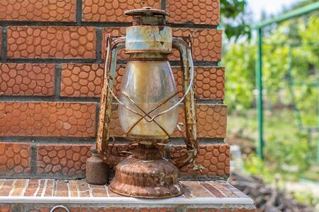 A rusty old flashlight lives out its life on a brick stove shelfの写真素材