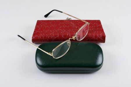 Reading glasses on the two cases, green and red colors isolated on a white background.の写真素材