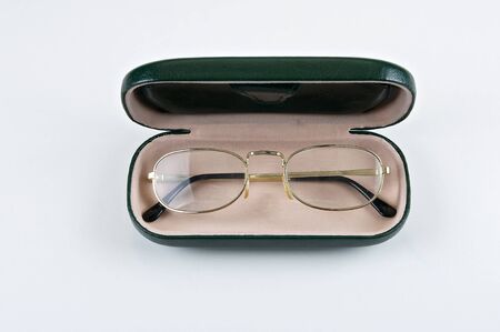 Reading glasses into green color carrying case on a white background.の写真素材