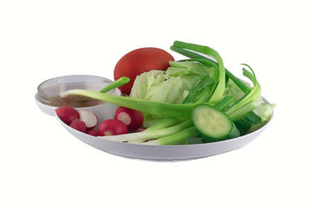 Vegetables tomato,green onion,radishes,lettuce and cucumber on the plate isolated on a white background の写真素材